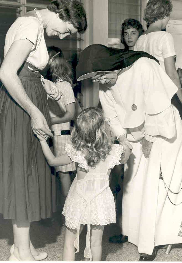 Sister Mary Alice Collins, O.P., holds the hand of a young girl during the Freshman Get Acquainted Party